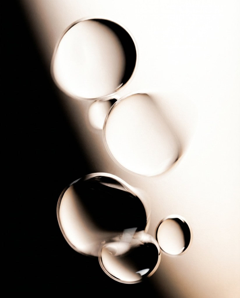 Azio formulation texture \u2014 oil droplets on a black-and-cream backdrop